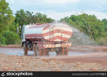 Water truck sprays water for a new road construction site.