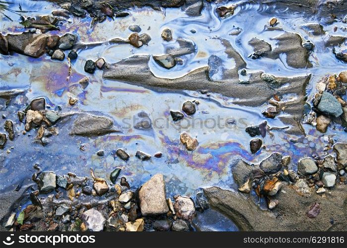 water with different colored patches of gasoline and oil