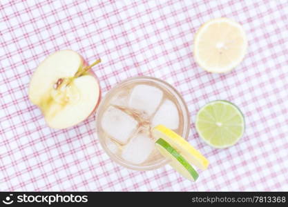 water with lemon and lime,apple in a glass with ice