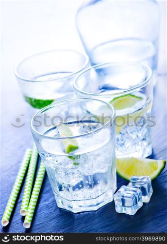 water with lemon in the glass and on a table