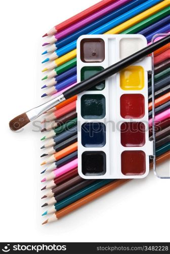 watercolor paints and color pencils isolated on a white background