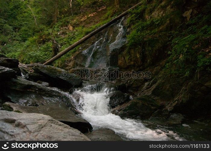Waterfall and alpine river in summer alpine vacation tourism