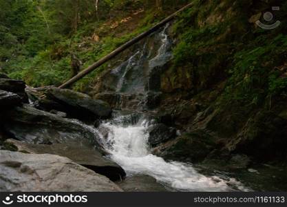 Waterfall and alpine river in summer alpine vacation tourism
