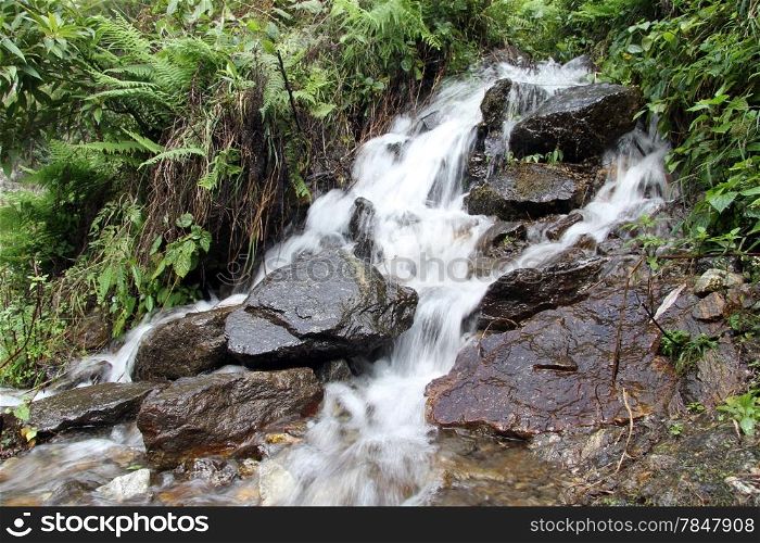Waterfall and green grass in the mountain in Nepal