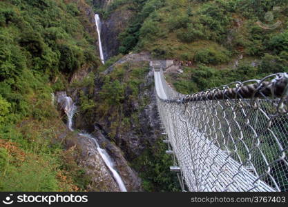 Waterfall and suspension bridge in Nepal
