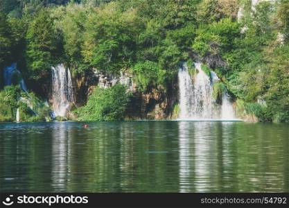 Waterfall at beautiful green summer forest lake. Plitvice Lake Nationak Park, Croatia