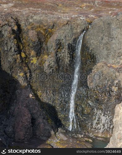 Waterfall. Closeup of a high waterfall in a rocky environment on Disko Island in Greenland