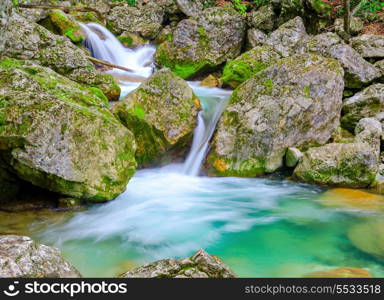 Waterfall in mountain rainforest with turquoise lagoon