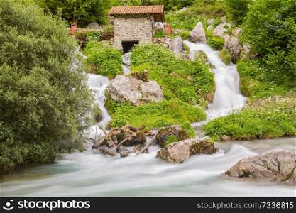 Waterfall in the Cares River located in the Picos de Europa National Park, Spain. Low shutter speed picture