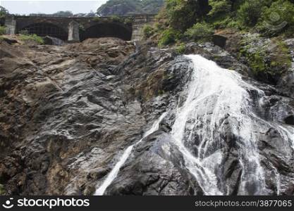 Waterfall in the jungle, a beautiful view of the railway on cliff .Indiya Goa.