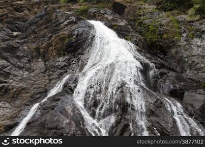 Waterfall in the jungle, a beautiful view of the steep rock .Indiya Goa.