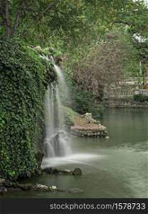 Waterfall in the pond of the crystal palace of Retiro Park. Madrid. Spain
