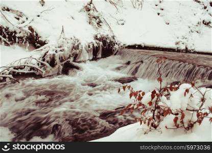 Waterfall mountain river in a forest in winter. Waterfall mountain river