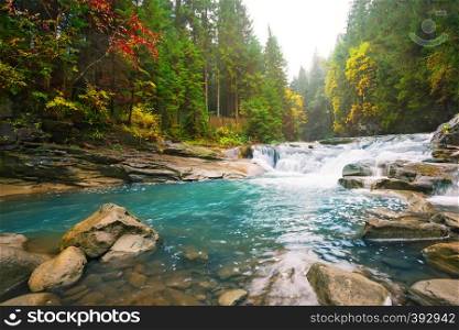 Waterfall on a mountain river in the forest among bright trees. Waterfall on mountain river in the forest