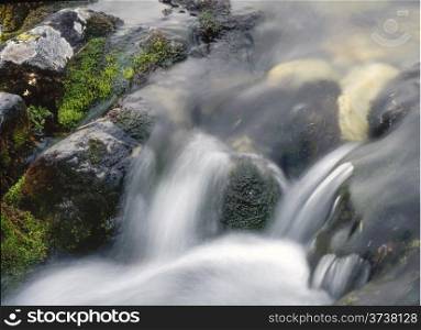 waterfall over rocks in mountain
