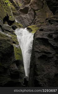 Waterfall over rocky cliffs in Iceland