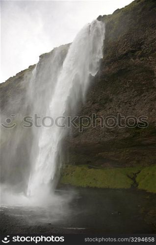 Waterfall over rocky cliffs in Iceland