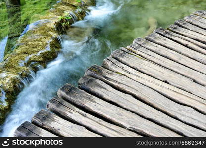 waterfalls on slopes of mountains and bridge&#xA;