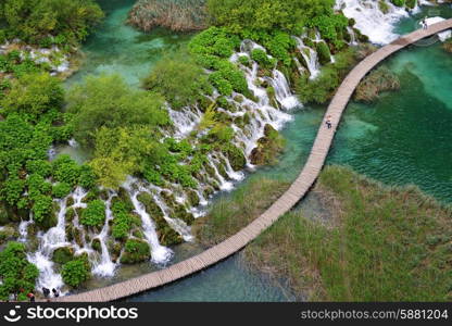 waterfalls on slopes of mountains and bridge&#xA;