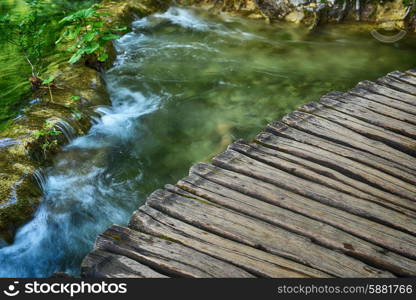 waterfalls on slopes of mountains and bridge&#xA;