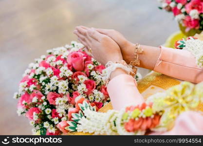 Watering ceremony for prosperity Thai wedding. The elder is pouring water and blessing the married couple to be happy. Conch shell decorated with gold. Inside the water And poured on the bride’s hand.