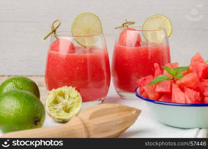 Watermelon fresh juice with mint leaves and lime citrus on wooden background