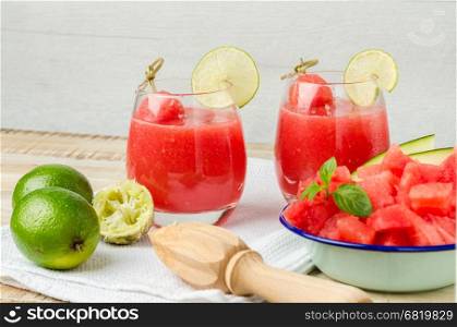 Watermelon fresh juice with mint leaves and lime citrus on wooden background