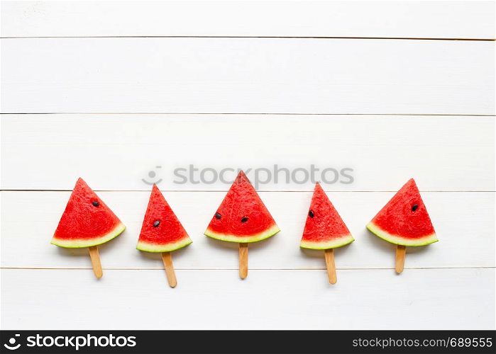 Watermelon slice popsicles on white wooden background. Copy space