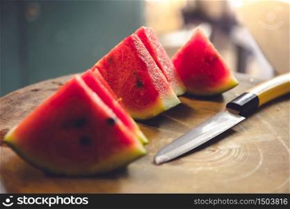 Watermelon slices in a wooden cutting board and cutlery