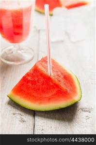 watermelon with drink straw on white wooden background, close up