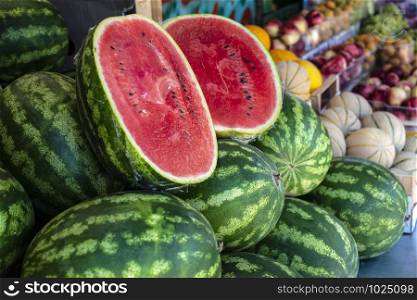 Watermelons on shelf. Cutted watermelon on street market. Summer Fruits.