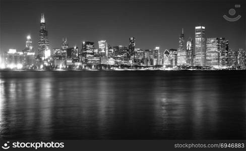 Waters of Lake Michigan reflect the light of tall buildings comprising the Chicago city skyline