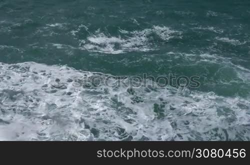 Waterscape with rough wavy turquoise sea making splashes