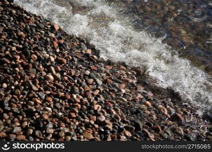 Wave and small stones at seashore