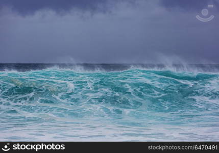 Wave. Blue wave on the beach. Blur background and sunlight spots. Peaceful natural background.