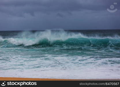 Wave. Blue wave on the beach. Blur background and sunlight spots. Peaceful natural background.