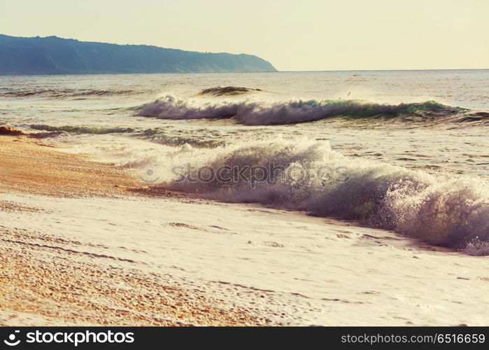 Wave. Blue wave on the beach. Blur background and sunlight spots. Peaceful natural background.