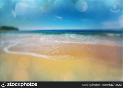 Wave. Blue wave on the beach. Blur background and sunlight spots. Peaceful natural background.