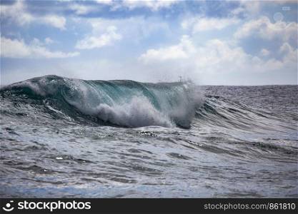 Wave breaks with water turquoise colors as a closeup on Hawaii