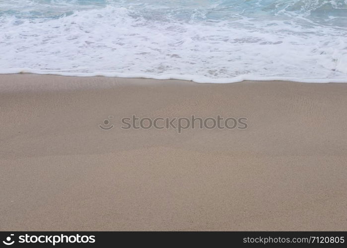 Wave of the sea and white clean foam on the sandy beach with Copy space.