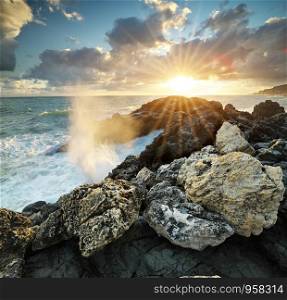 Wave splashing on the sea rocks shore. Nature composition.