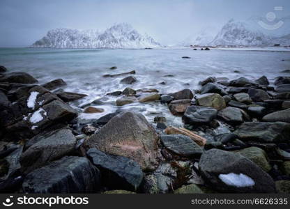 Waves and rocks on coast of Norwegian sea in fjord. Skagsanden beach, Flakstad, Lofoten islands, Norway. Long exposure motion blur. Coast of Norwegian sea