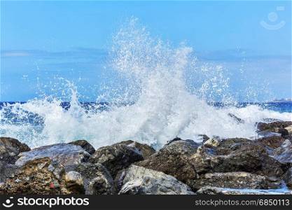Waves breaking in splashes on the coastal rocks