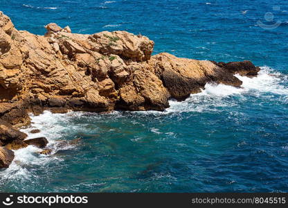 Waves breaking on rocky coast. View from above.