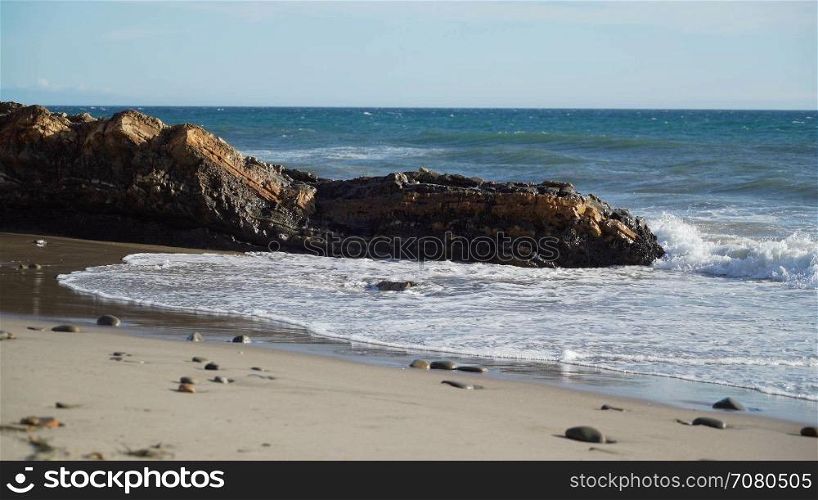 Waves crash along a rocky beach near Point Conception State Marine Reserve