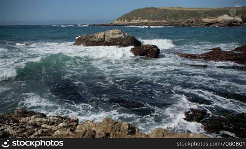 Waves crash on rocks near Spoonera??s Cove