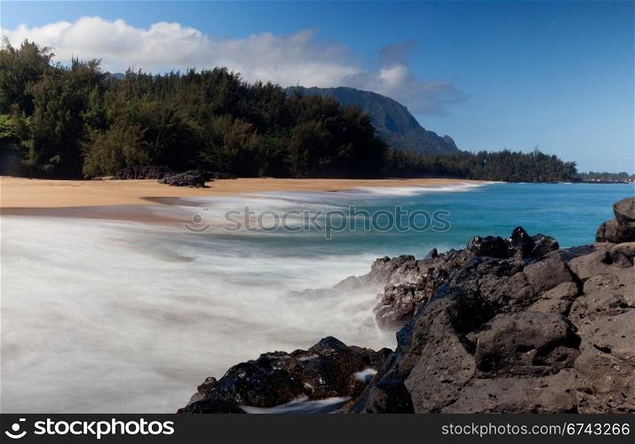 Waves crash onto Lumahai beach on Kauai Hawaii with Na Pali Coast