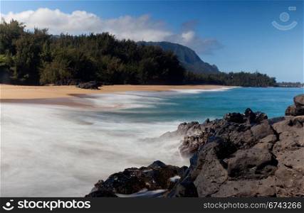 Waves crash onto Lumahai beach on Kauai Hawaii with Na Pali Coast