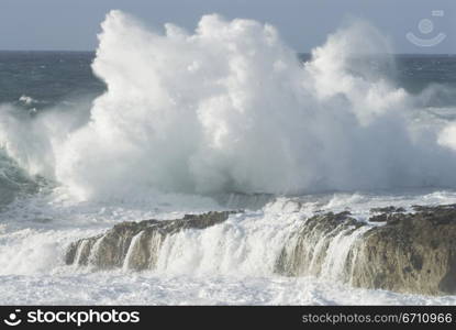 Waves crashing over a rock