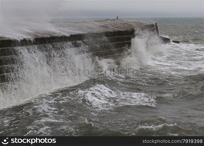 Waves crashing over The Cobb ? which protects the harbour. Famous scene in the film ?The French Lieutenant?s Woman? with Meryl Streep.